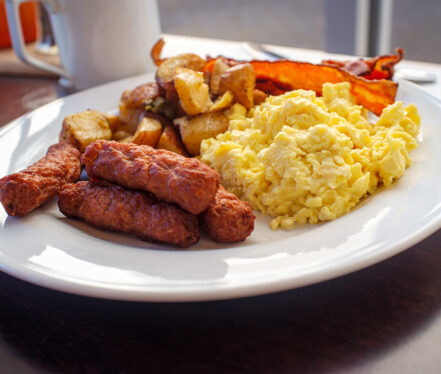 Scrambled eggs with breakfast sausage home fries and bacon